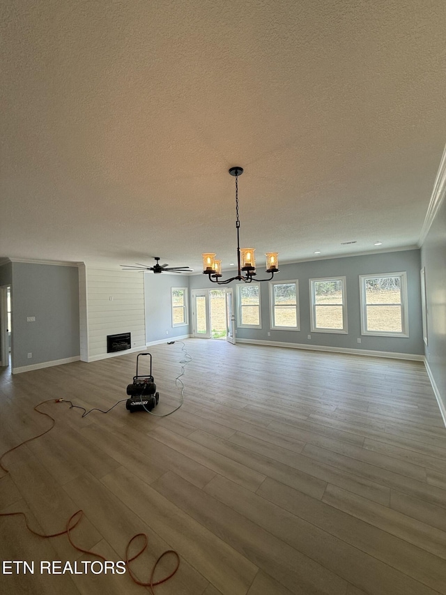 222 Ten Mile Ln, Ten Mile, TN 37880 - unfurnished living room featuring a textured ceiling, a chandelier, baseboards, wood finished floors, and ornamental molding