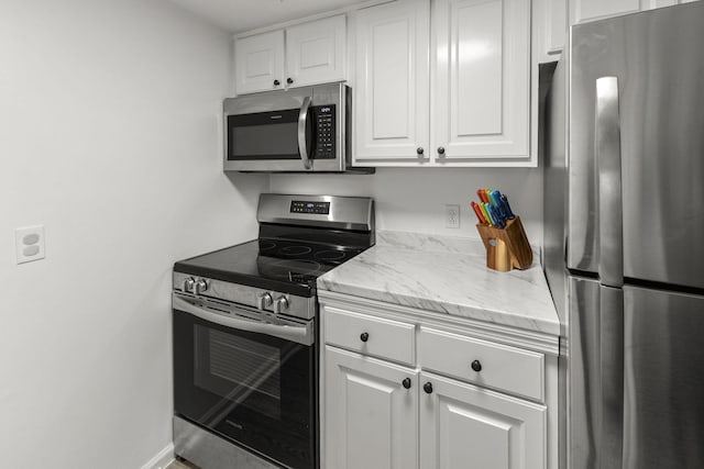 1129 W Main St Unit 21, Franklin, TN 37064 - kitchen with stainless steel appliances, white cabinets, and light stone counters