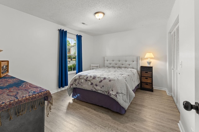1129 W Main St Unit 21, Franklin, TN 37064 - bedroom featuring wood finished floors, baseboards, a textured ceiling, and a closet