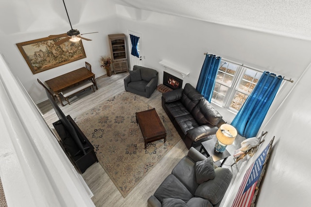 1129 W Main St Unit 21, Franklin, TN 37064 - living area featuring wood finished floors, a ceiling fan, a lit fireplace, vaulted ceiling, and a textured ceiling