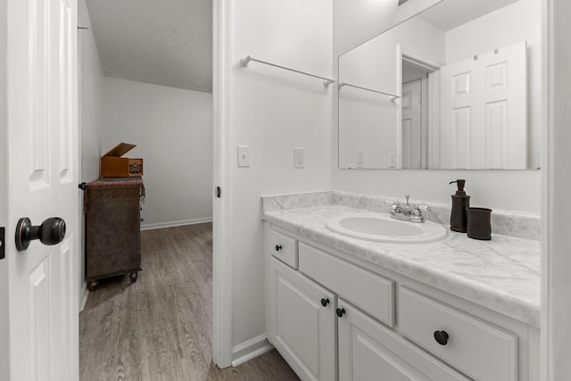 1129 W Main St Unit 21, Franklin, TN 37064 - bathroom with wood finished floors, vanity, a textured ceiling, and baseboards