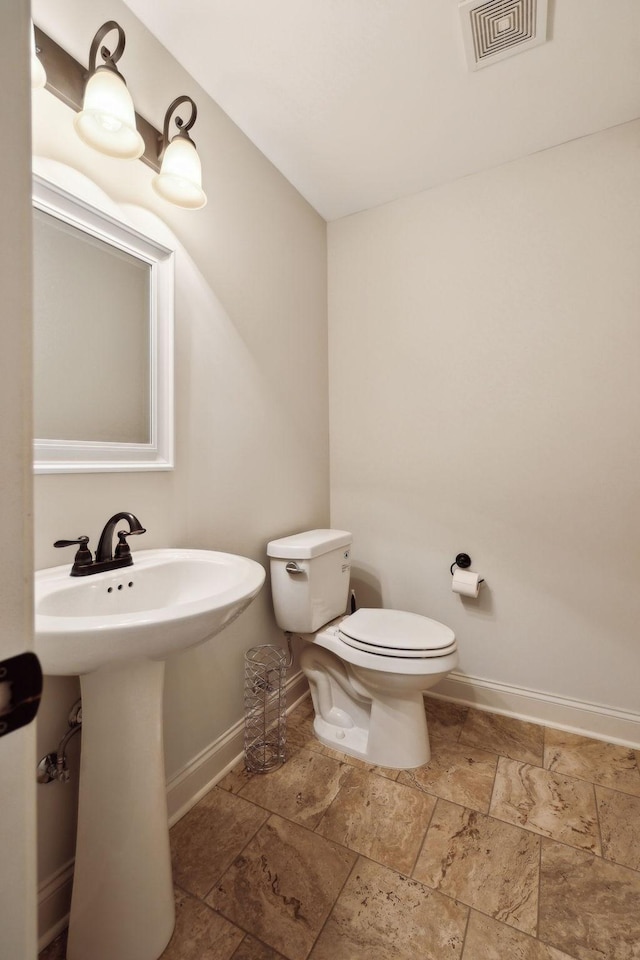 1403 Wade Hampton Ct, Lebanon, TN 37087 - bathroom featuring stone tile flooring, baseboards, toilet, and a sink