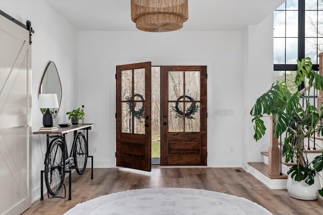 7361 Liberty Rd, Fairview, TN 37062 - entrance foyer featuring a barn door, wood finished floors, baseboards, and stairway
