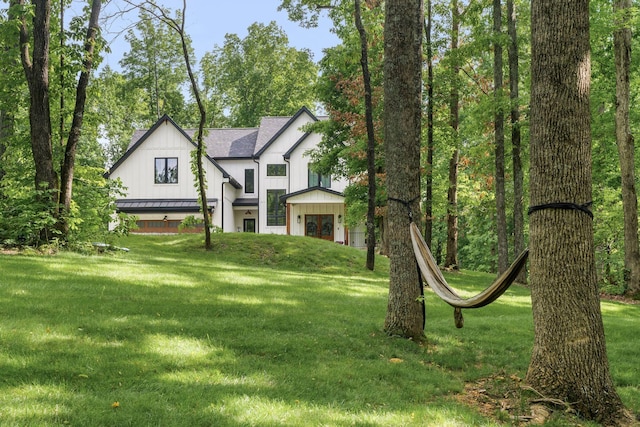7361 Liberty Rd, Fairview, TN 37062 - modern farmhouse style home featuring a standing seam roof, a front yard, metal roof, board and batten siding, and roof with shingles