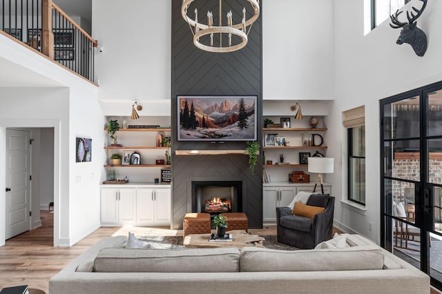 7361 Liberty Rd, Fairview, TN 37062 - living area with a high ceiling, light wood-type flooring, baseboards, a chandelier, and a large fireplace