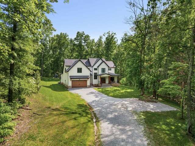 7361 Liberty Rd, Fairview, TN 37062 - modern inspired farmhouse featuring driveway, a front lawn, board and batten siding, and a view of trees