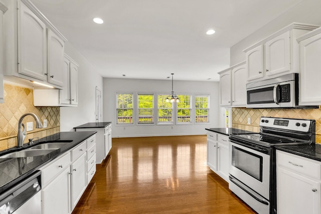 3015 Carpenters Pass, Spring Hill, TN 37174 - kitchen with stainless steel appliances, a sink, white cabinets, dark wood finished floors, and backsplash