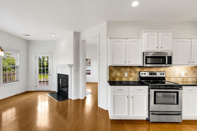 3015 Carpenters Pass, Spring Hill, TN 37174 - kitchen with appliances with stainless steel finishes, dark countertops, white cabinets, tasteful backsplash, and light wood-type flooring