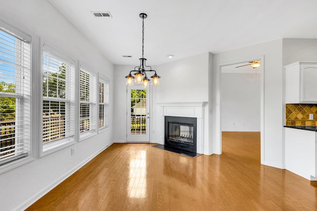 3015 Carpenters Pass, Spring Hill, TN 37174 - unfurnished living room with plenty of natural light, light wood-style floors, a chandelier, and a fireplace with flush hearth