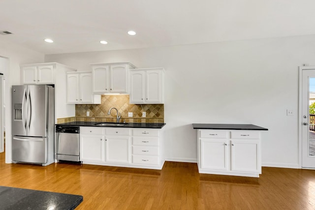 3015 Carpenters Pass, Spring Hill, TN 37174 - kitchen featuring stainless steel appliances, a sink, white cabinetry, light wood-style flooring, and backsplash