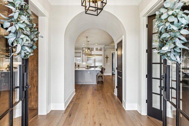 5012 Toll Road Ct, Thompsons Station, TN 37179 - foyer with arched walkways, a chandelier, wood finished floors, baseboards, and french doors