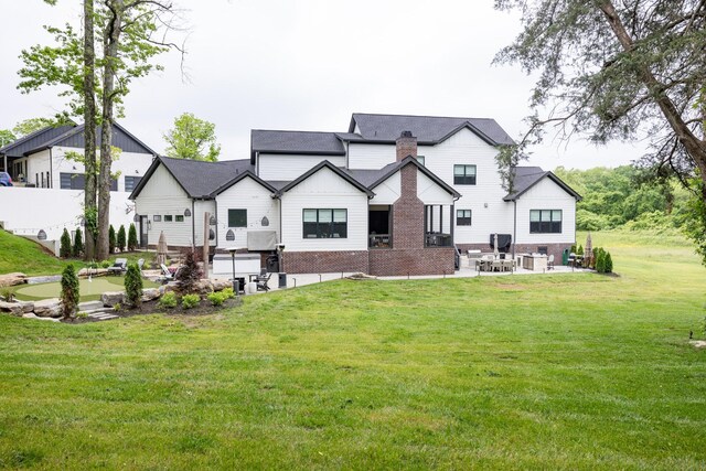 5012 Toll Road Ct, Thompsons Station, TN 37179 - rear view of house featuring a patio, a yard, a chimney, brick siding, and board and batten siding