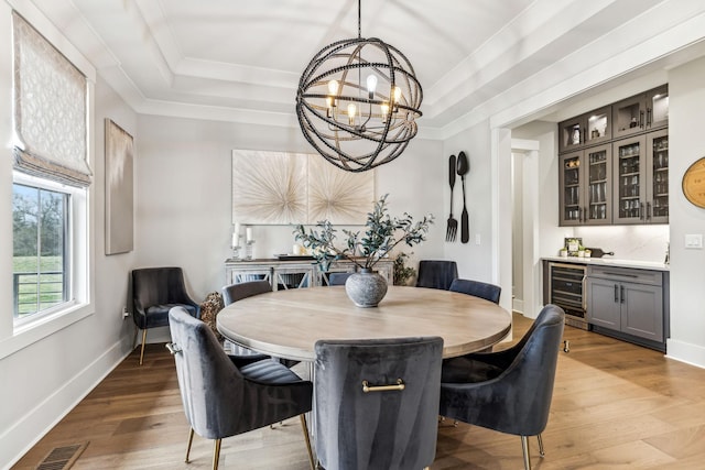 5012 Toll Road Ct, Thompsons Station, TN 37179 - dining room featuring wine cooler, a chandelier, bar, a raised ceiling, and wood finished floors