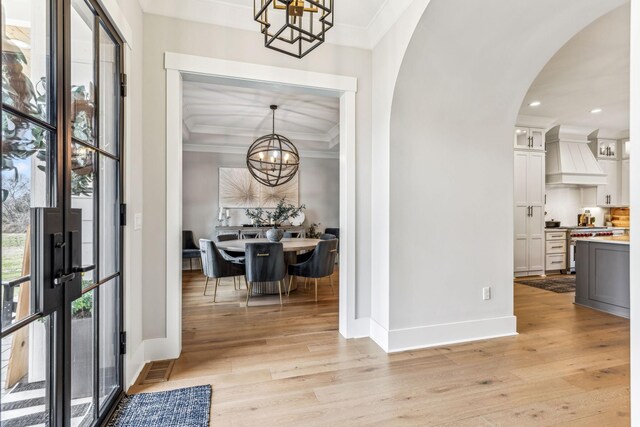 5012 Toll Road Ct, Thompsons Station, TN 37179 - foyer with a chandelier, crown molding, arched walkways, light wood-type flooring, and baseboards