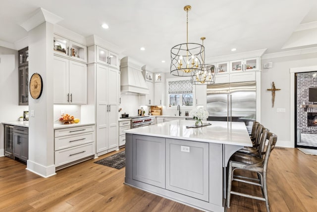 5012 Toll Road Ct, Thompsons Station, TN 37179 - kitchen featuring premium range hood, light wood-style floors, light countertops, a sink, and a chandelier