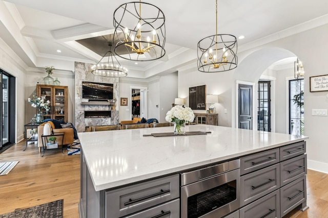5012 Toll Road Ct, Thompsons Station, TN 37179 - kitchen with gray cabinets, stainless steel microwave, open floor plan, arched walkways, and a chandelier