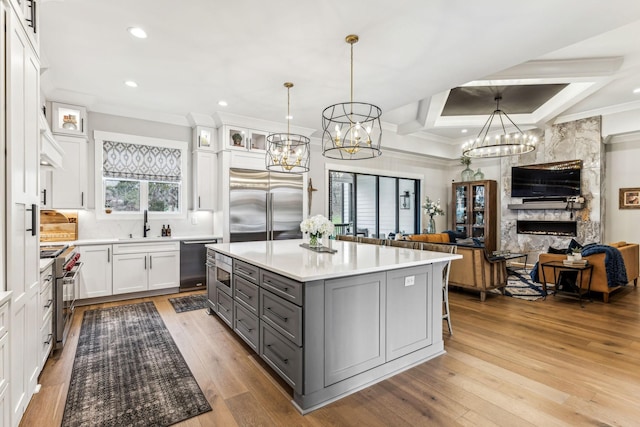 5012 Toll Road Ct, Thompsons Station, TN 37179 - kitchen with gray cabinetry, high end appliances, a chandelier, open floor plan, and ornamental molding