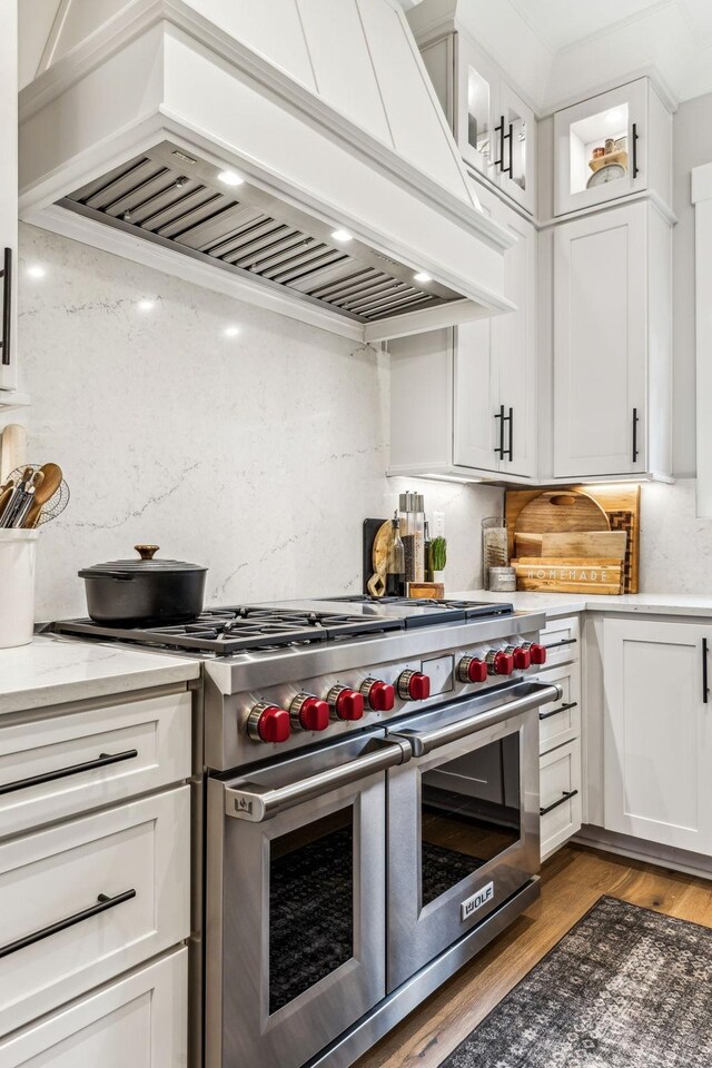 5012 Toll Road Ct, Thompsons Station, TN 37179 - kitchen featuring range with two ovens, custom exhaust hood, white cabinets, glass insert cabinets, and wood finished floors