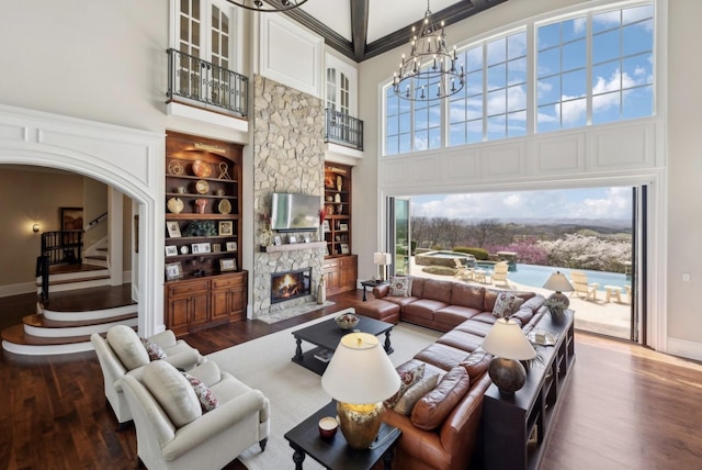 513 King Richards Ct, Franklin, TN 37067 - living room featuring a towering ceiling, wood finished floors, a chandelier, built in shelves, and baseboards