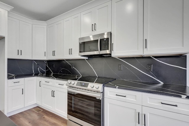 7592 Grasshopper Rd, Georgetown, TN 37336 - kitchen featuring appliances with stainless steel finishes, dark countertops, wood finished floors, and white cabinets