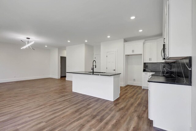 7592 Grasshopper Rd, Georgetown, TN 37336 - kitchen with dark countertops, a sink, recessed lighting, wood finished floors, and white cabinetry