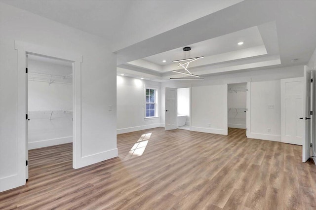 7592 Grasshopper Rd, Georgetown, TN 37336 - unfurnished living room featuring a raised ceiling, baseboards, light wood-style flooring, recessed lighting, and a chandelier