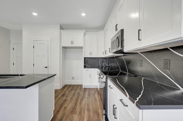 7592 Grasshopper Rd, Georgetown, TN 37336 - kitchen with appliances with stainless steel finishes, dark countertops, wood finished floors, white cabinetry, and recessed lighting