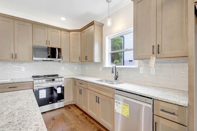 7387 Gamble Rd Lot # 4, Georgetown, TN 37336 - kitchen featuring appliances with stainless steel finishes, a sink, backsplash, hanging light fixtures, and light wood-style flooring