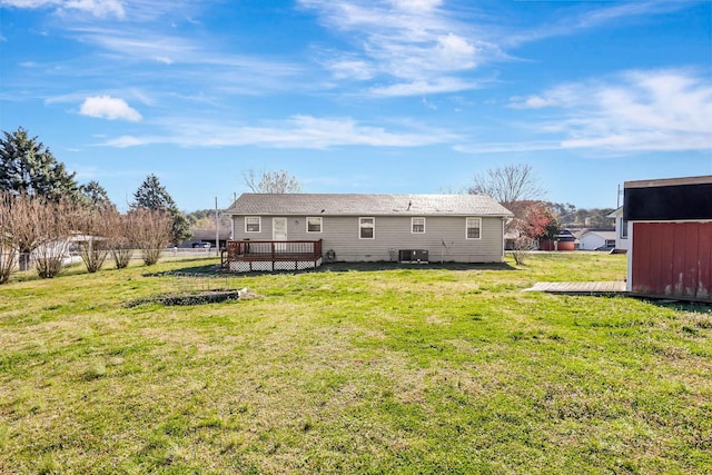 back of property with a wooden deck, a yard, a storage unit, an outdoor structure, and central air condition unit