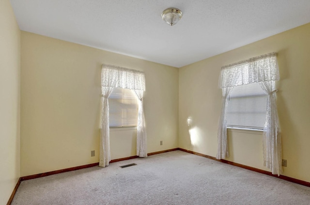 unfurnished room with carpet floors and baseboards
