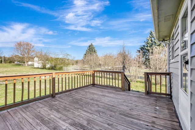 wooden deck featuring a lawn