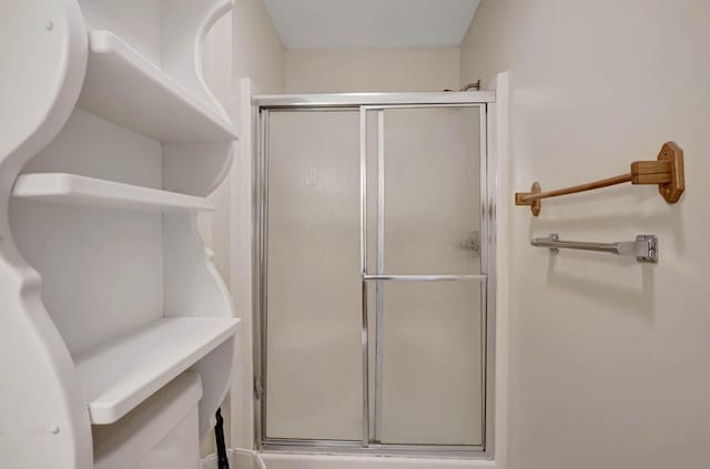 bathroom featuring a shower stall and toilet