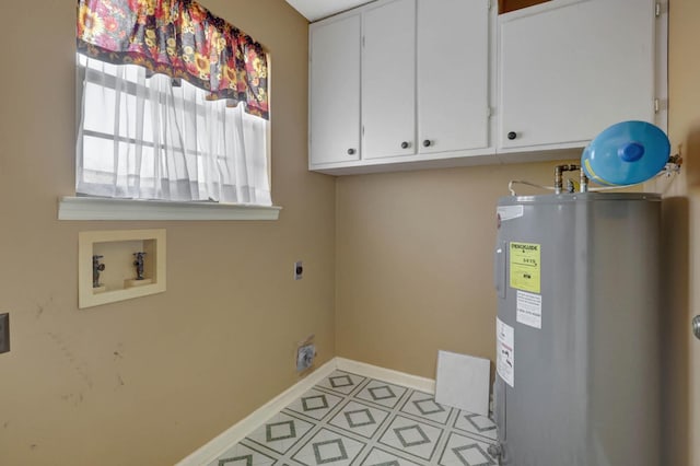 washroom featuring hookup for an electric dryer, water heater, washer hookup, cabinet space, and baseboards