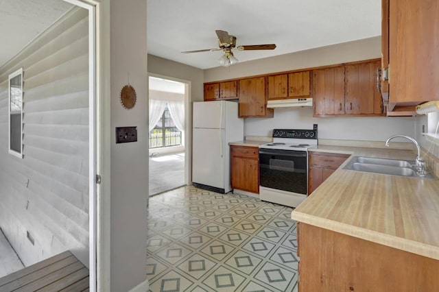 kitchen with range with electric cooktop, freestanding refrigerator, a sink, under cabinet range hood, and light countertops