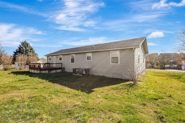 rear view of property with a wooden deck and a yard