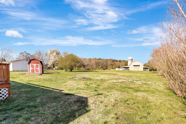 view of green lawn with an outdoor structure and a shed