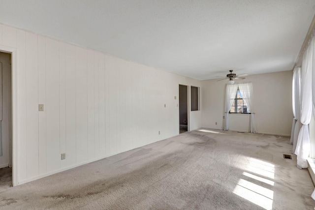 spare room featuring a ceiling fan and carpet floors