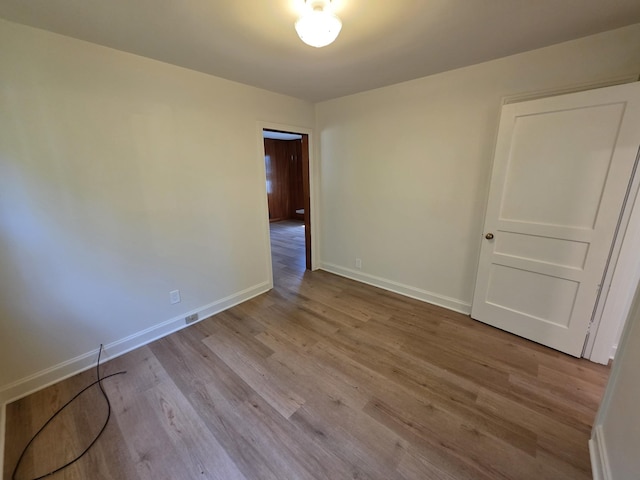 unfurnished room featuring wood finished floors and baseboards