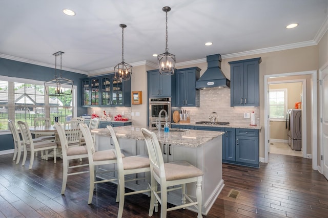 105 Bowwater Pl, Gallatin, TN 37066 - kitchen featuring custom range hood, blue cabinetry, a sink, glass insert cabinets, and a kitchen breakfast bar
