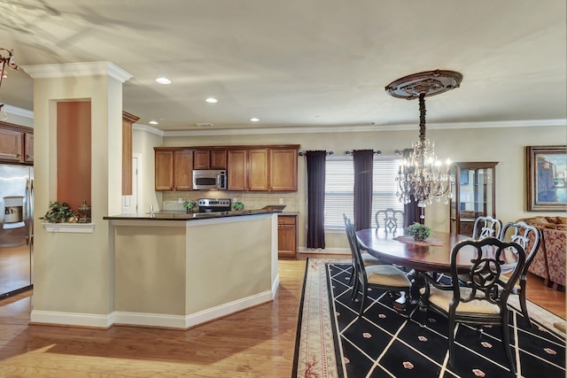 3157 Locust Holw, Nolensville, TN 37135 - kitchen with stainless steel appliances, brown cabinets, light wood finished floors, a chandelier, and dark countertops