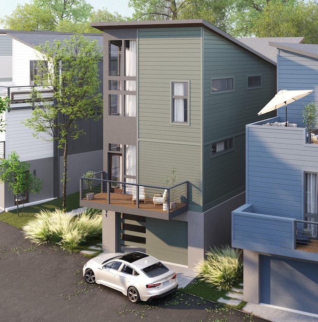 back of property featuring an attached garage, asphalt driveway, stucco siding, and a balcony