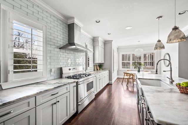 kitchen with double oven range, wall chimney exhaust hood, a sink, crown molding, and dark wood finished floors