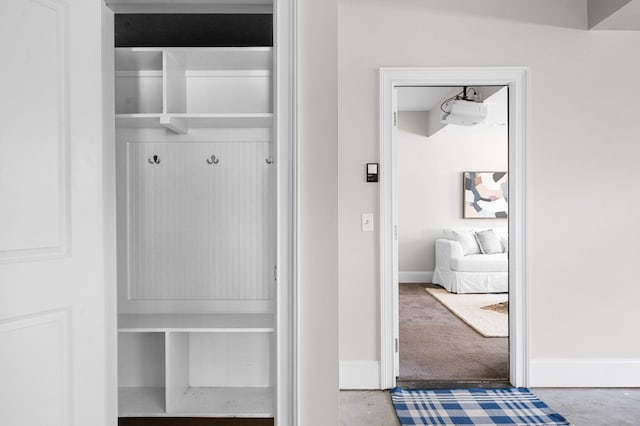mudroom featuring baseboards and carpet flooring