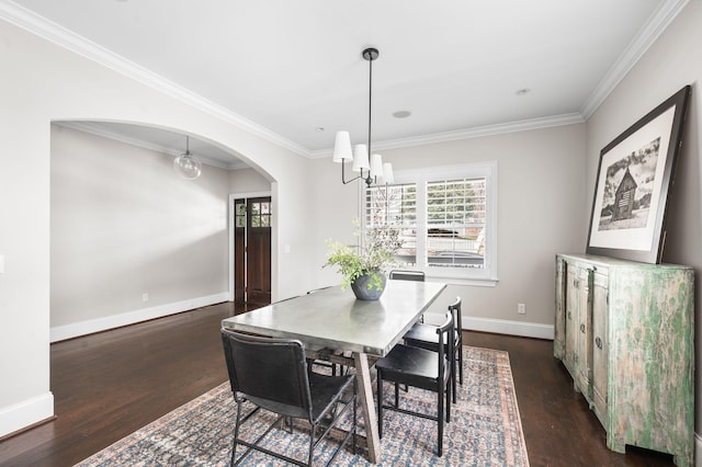 dining area with a chandelier, arched walkways, wood finished floors, baseboards, and ornamental molding