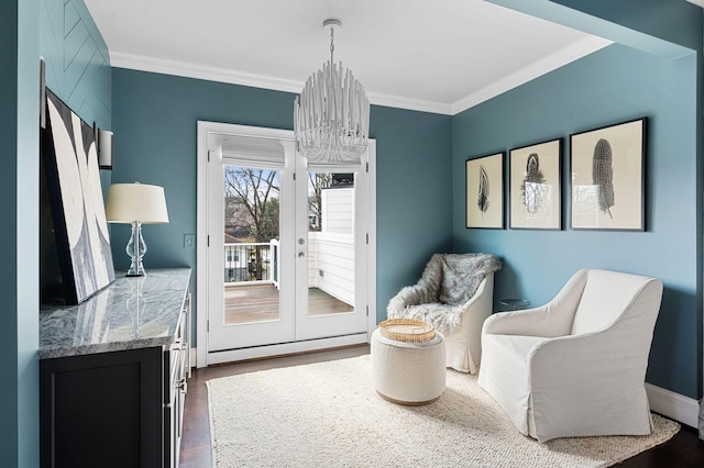 living area featuring a chandelier, ornamental molding, dark wood finished floors, french doors, and baseboards