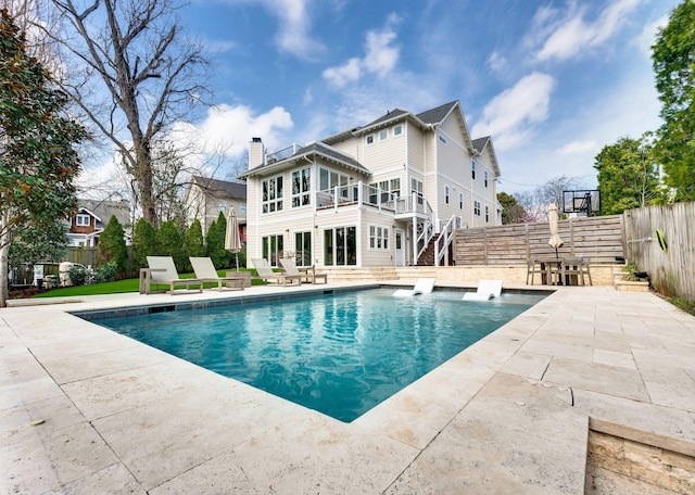 view of pool featuring a patio area, stairway, and a fenced backyard