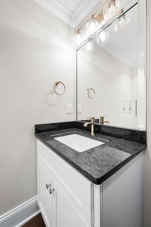 bathroom with crown molding, vanity, and baseboards