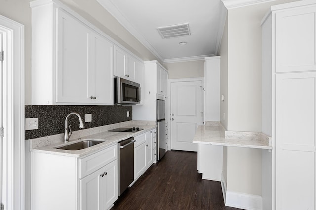 kitchen with appliances with stainless steel finishes, a sink, white cabinetry, ornamental molding, and dark wood-style floors