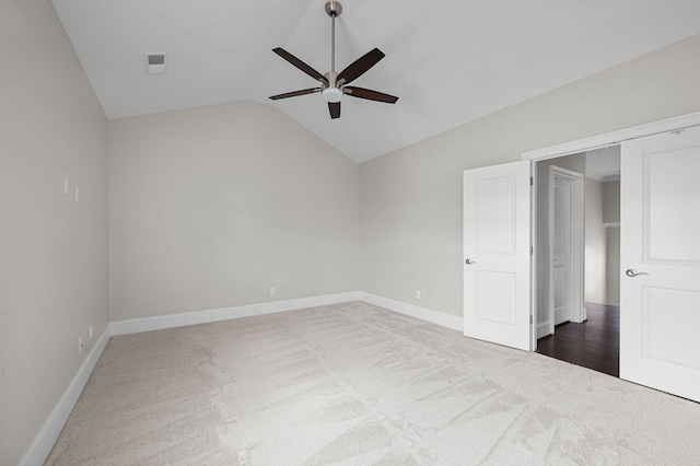 unfurnished bedroom featuring carpet flooring, lofted ceiling, baseboards, and a ceiling fan