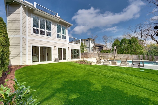 rear view of house featuring a balcony and a patio